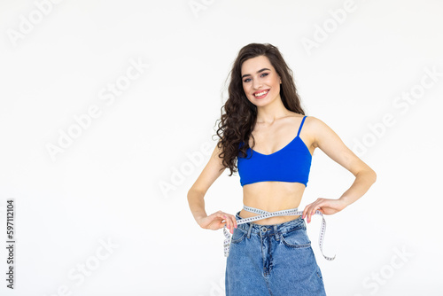Young woman measuring her waist isolated on white background