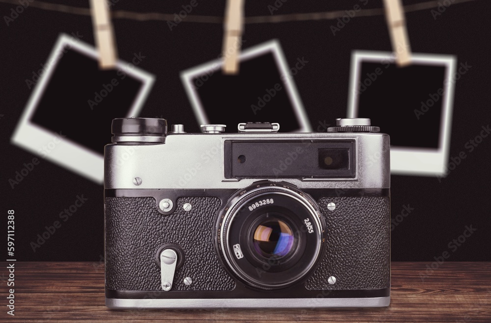 Old retro photo camera with photo frame on background