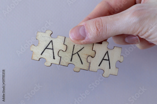 The acronym AKA, which stands for Also Known As. The letters written on the puzzles. photo