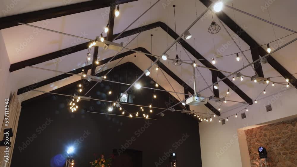 Ceiling of spacious banquet hall with beams, lighting, lanterns and