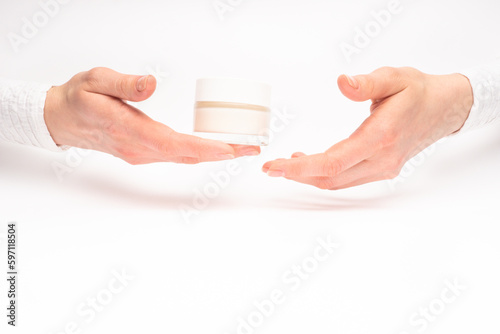 Obraz na płótnie Mock-up of beautiful woman's hand holds round jar or container of cosmetic product cream or lotion on white isolated background. Concept of beauty, spa industry, skin care. Close-up, copy space w salonie