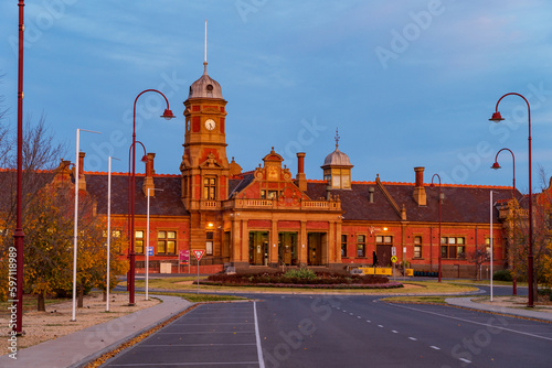 A grand old railway station with a clock tower at twilight photo