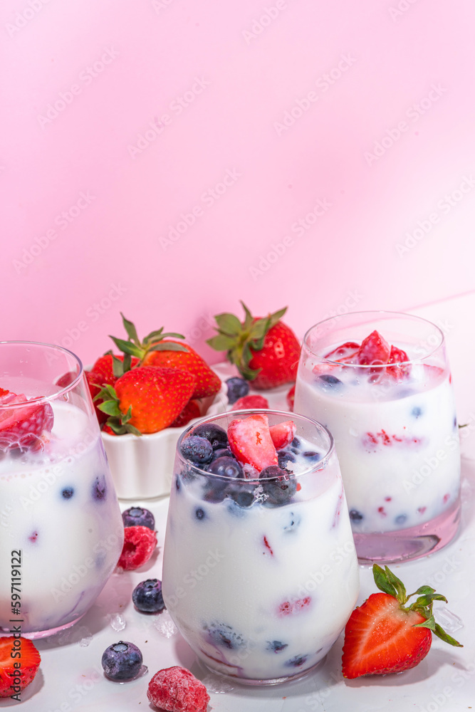 Summer milk berry non-alcohol cocktail, Sweet vegan coconut milk non-dairy mocktail, with fresh strawberry, blueberry, raspberry and crushed ice, on bright trendy pink background Summer milk berry non-alcohol cocktail, Sweet vegan coconut milk non-dairy mocktail, with fresh strawberry, blueberry, raspberry and crushed ice, on bright trendy pink background