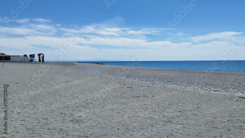 Spiaggia mare cielo nuvole tutto quello che si vede in questa fotografia scattata su una delle più belle spiagge del mar mediterraneo photo