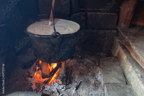 Bacówka w Jabłonce nad Czarną Orawą i okolice. Gar z gotującym się mlekiem z pianą i drewnianą łyżką nad płonącym ogniskiem. 