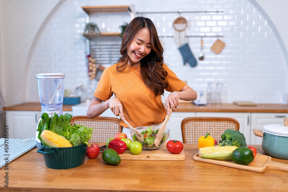Beautiful young woman happy portrait cooking fresh organic clean food fruit at home modern kitchen
