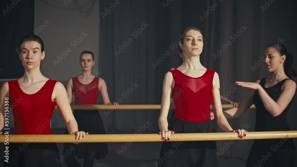 Classes of a group of ballerinas under the sensitive guidance of a serious trainer. Ballet techniques for improving the physical form. High quality 4k footage