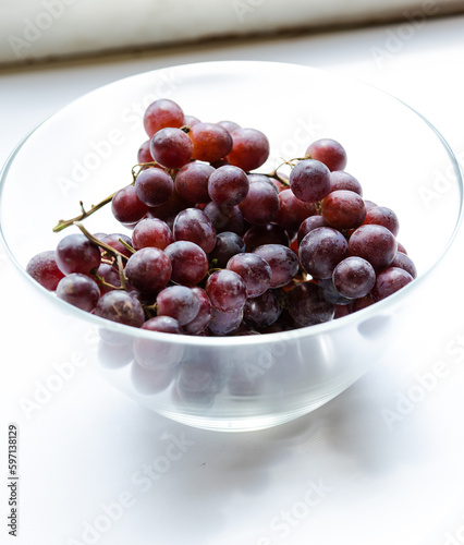 bunch of grapes close up in glass bowl on white background