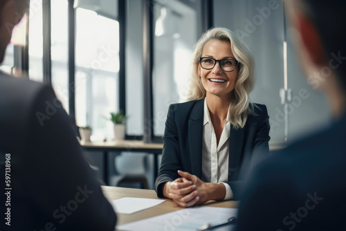 Friendly smiling woman sitting on a desk talking to customers sitting opposite to her in a modern office. Generative AI