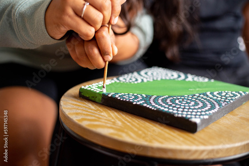 Close-up of a young Aboriginal woman painting photo