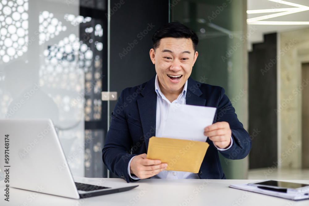 Successful asian businessman working inside office with laptop at workplace male boss in business suit received notification mail envelope with good news, entrepreneur happy with achievement results.