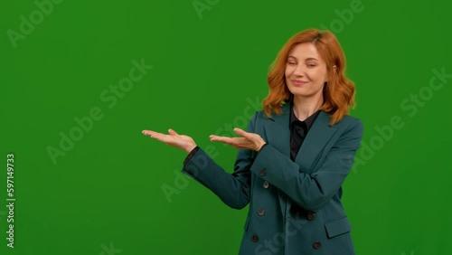 Woman hand showing to the right with green screen background. Female is looking into the camera showing direction. Gesture of copy space concept. photo