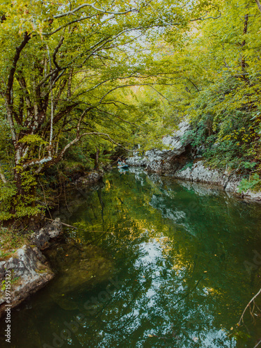 A group of friends enjoying having fun and kayaking while exploring the calm river, surrounding forest and large natural river canyons