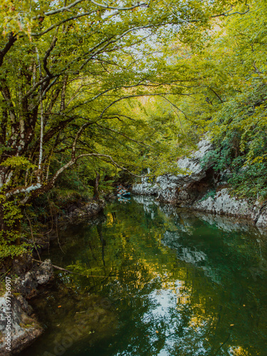 A group of friends enjoying having fun and kayaking while exploring the calm river  surrounding forest and large natural river canyons