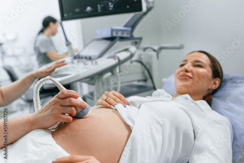 Close up view, scanning. Pregnant woman is lying down in the hospital, doctor does ultrasound