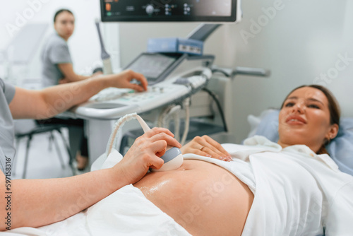 Focused close up view. Pregnant woman is lying down in the hospital, doctor does ultrasound