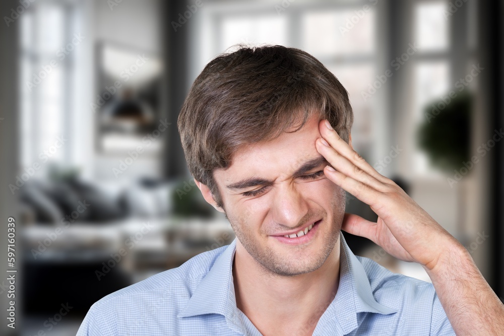 Man suffering from head pain in room Man suffering from head pain in room