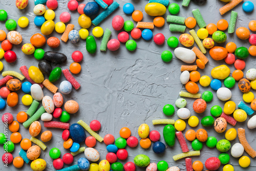 Mixed collection of colorful candy, on colored background. Flat lay, top view. frame of colorful chocolate coated candy