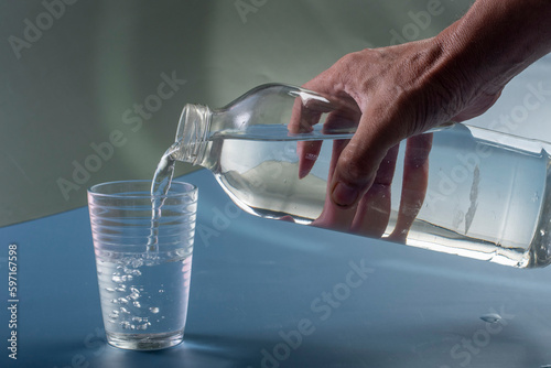 Detail of person filling glass of water. hydration concept