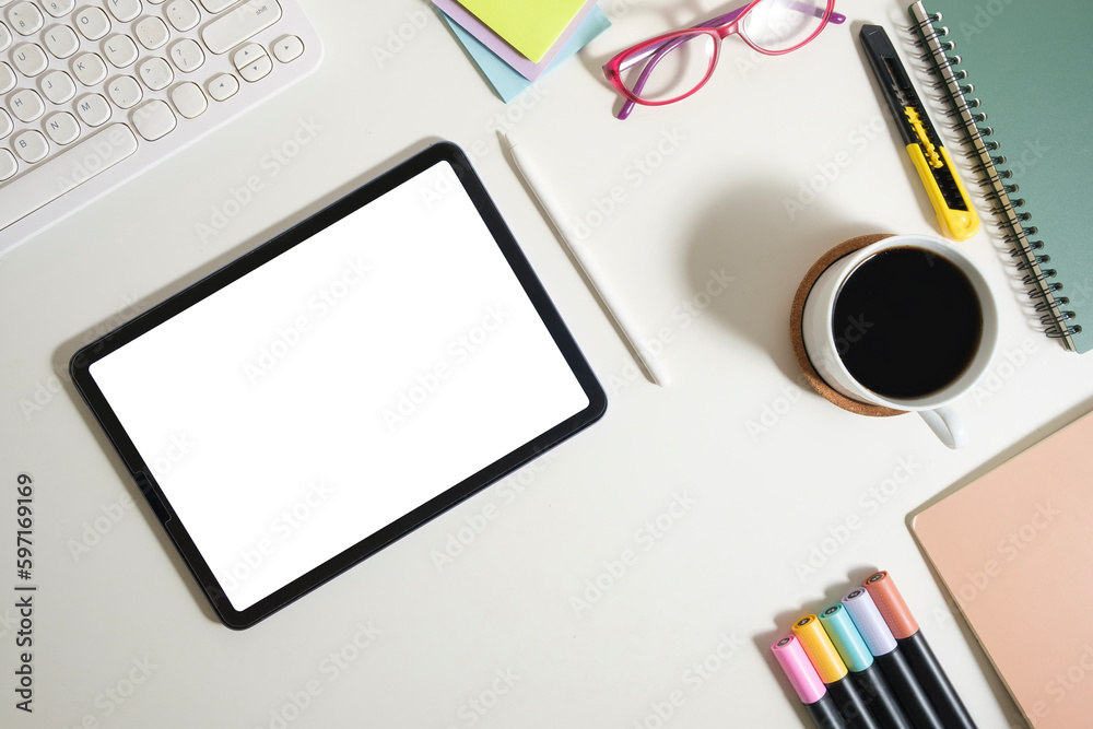 Digital tablet with blank screen, coffee cup, glasses and stationery on white working desk.