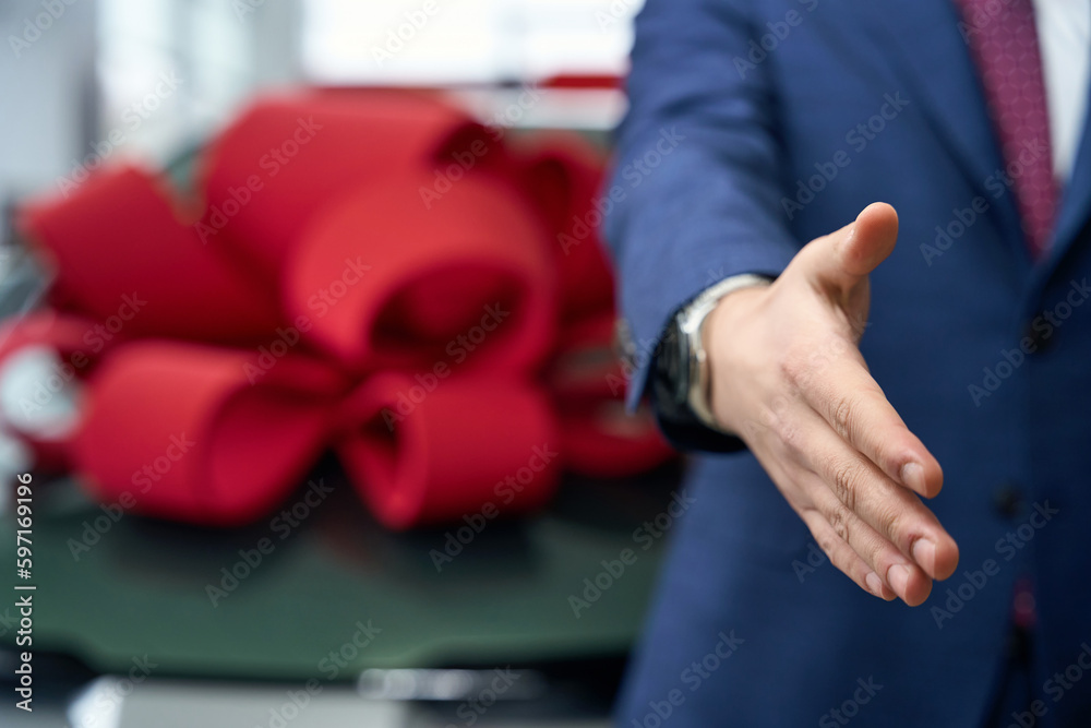 Man in a business suit extends his hand to greet
