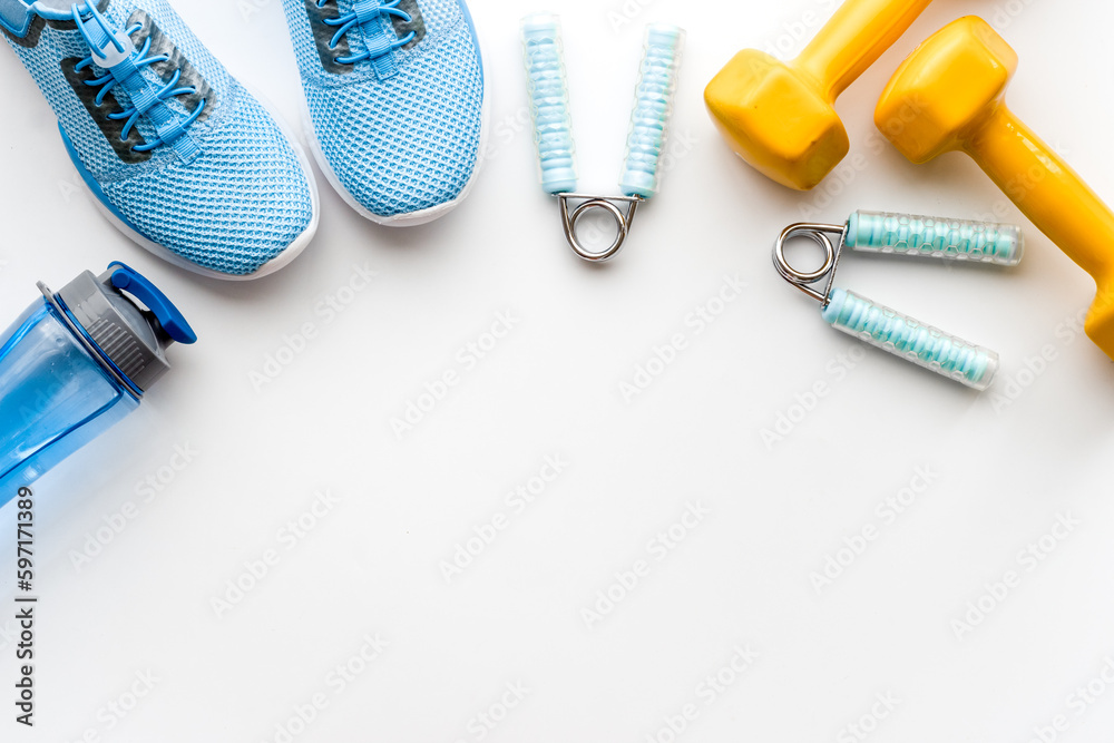 Naklejka premium Sport fitness background with sneakers and dumbbells, top view