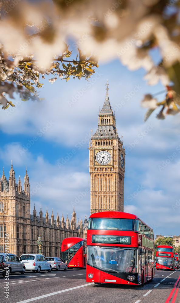 Famous Big Ben with red double decker bus on bridge over Thames river during springtime in London, England, UK