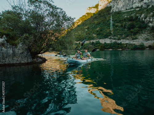 A group of friends enjoying having fun and kayaking while exploring the calm river  surrounding forest and large natural river canyons