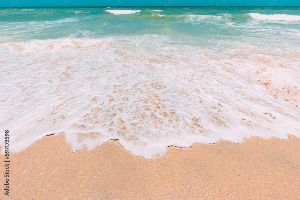 Ocean water foam splashes washing sandy beach. Amazing landscape scenery. Crashing waves of sandy coastline. Sea ocean water surface with small waves. Beautiful background with copy space. Nature - obrazy, fototapety, plakaty 