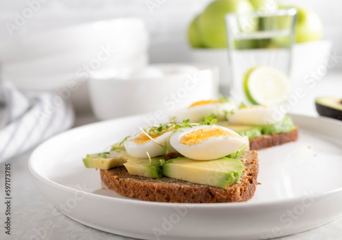 Avocado egg sandwich with rye bread on a plate
