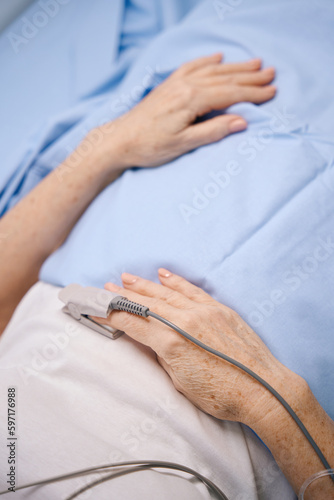 Elderly woman lies on a hospital bed incardiology department