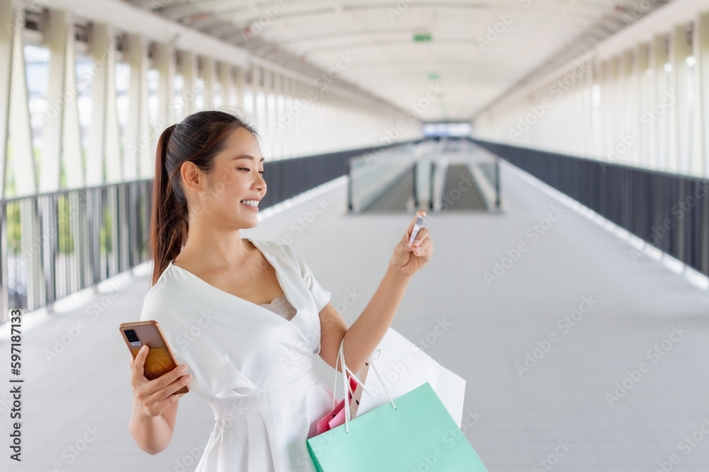 Portrait of happy smiling woman with shopping bags in corridor walk way. Beautiful woman with a paper bag. Portrait of happy smiling woman with shopping bags in corridor walk way. Beautiful woman with a paper bag.