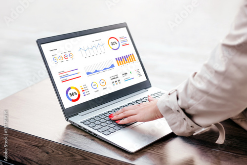 woman with laptop and financial charts at screen