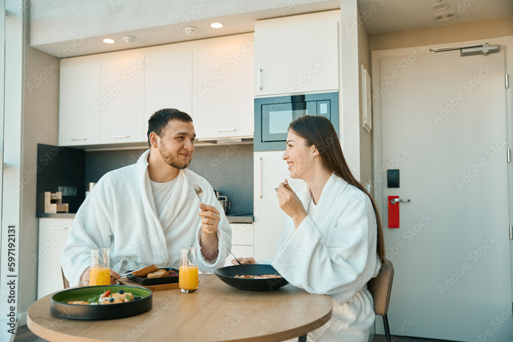 Beautiful young couple has breakfast in a cozy environment Beautiful young couple has breakfast in a cozy environment