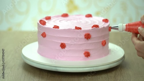 Confectioner at work. Cream cake decorating.