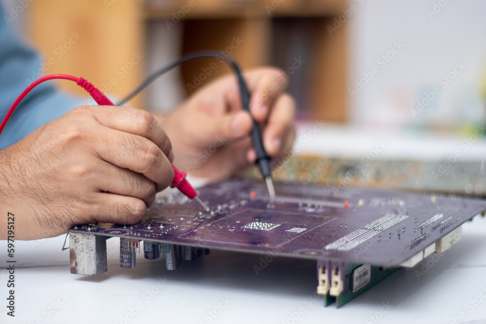 Technician using tool to measure circuit board, check and repair