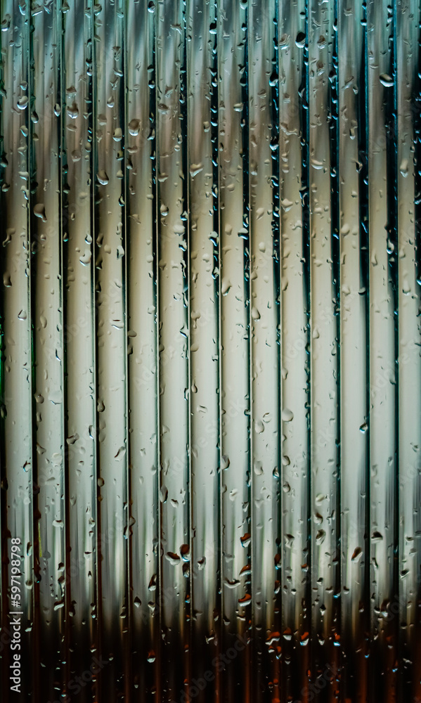 Window glass surface with a strip pattern in the rain. Shot in close up with selective focus. Great for background and pattern designs. Window glass surface with a strip pattern in the rain. Shot in close up with selective focus. Great for background and pattern designs.