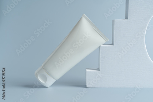 A white tube of face cream lying on an arch, marketing presentation, mock up, branding