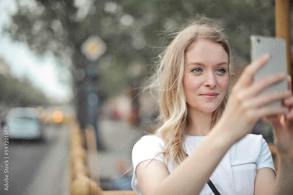 portrait of a young woman with smartphone in the street