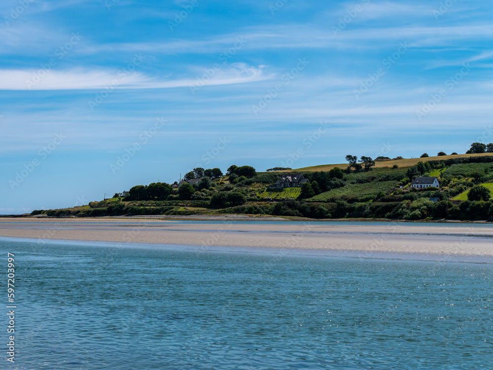 blue sky with white clouds over the sea coast in Ireland. Seaside landscape on a sunny summer day, body of water under blue sky.
