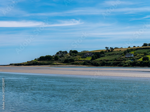 blue sky with white clouds over the sea coast in Ireland. Seaside landscape on a sunny summer day, body of water under blue sky. © Oleksii