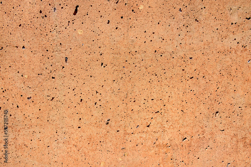 Stunning light red concrete background with numerous small holes and flaws