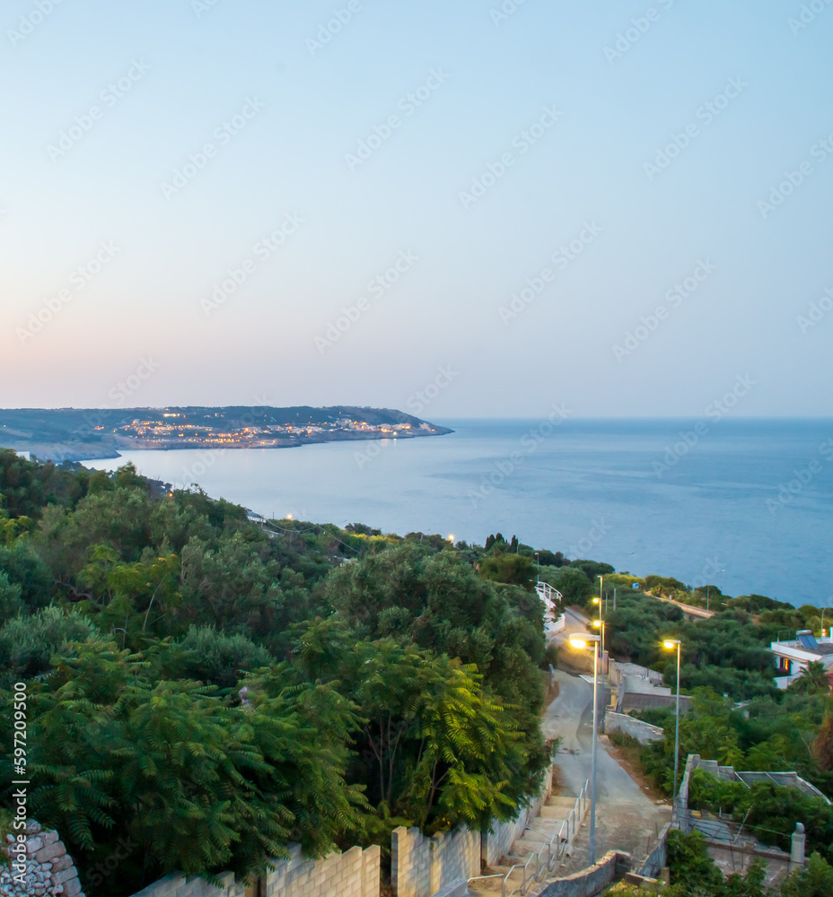 Vistas de la costa desde la plaza Armando Perotti en Castro, Italia. A lo lejos la ciudad de Santa Cesarea Terme y las tranquilas aguas del mar Jónico al atardecer.