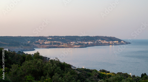 Vistas de la costa desde la plaza Armando Perotti en Castro, Italia. A lo lejos la ciudad de Santa Cesarea Terme y las tranquilas aguas del mar Jónico al atardecer.