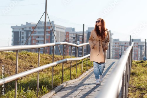 Full length view of young caucasian girl with red hair and toothy smile walking