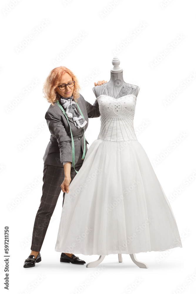 Woman measuring a bridal gown on a mannequin doll