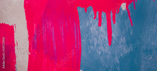 Messy paint strokes and smudges on an old painted wall background. Abstract wall surface with part of graffiti. Colorful drips, flows, streaks of paint and paint sprays