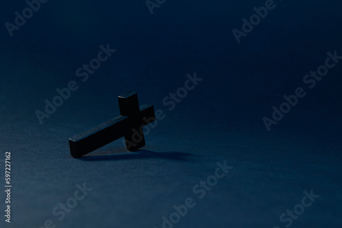 Black wooden traditional cross fallen down and lying on edge at an angle on the Fototapet