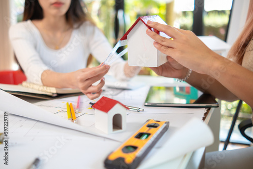 Engineers and designers are discussing the layout of the house and the construction schedule to be completed on schedule. House construction ideas with a team of professional engineers and designers.