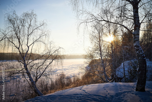 Sunrise on winter morning and trees with bare branches on a cold sunny time and snow on field © keleny
